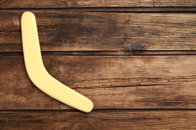 Photo of Boomerang on wooden background, top view. Space for text