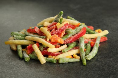 Photo of Mix of different frozen vegetables on gray table, closeup