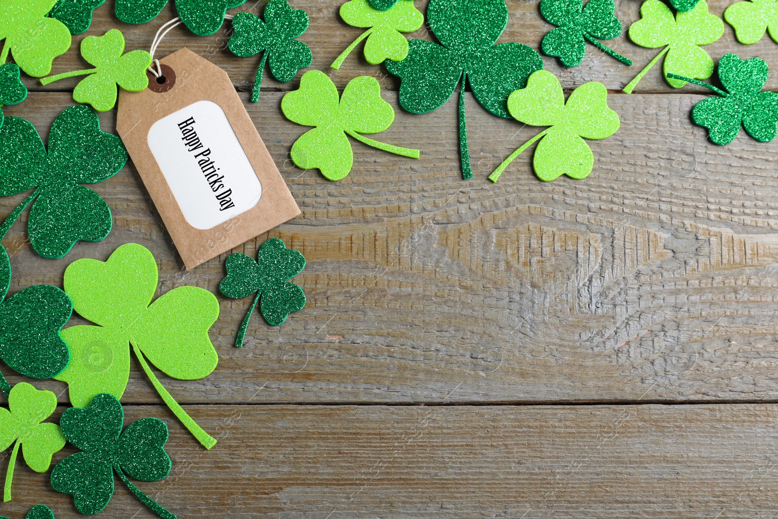 Photo of Flat lay composition with clover leaves on wooden table, space for text. St. Patrick's Day celebration