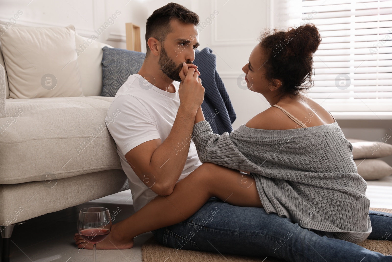 Photo of Lovely couple enjoying each other on floor in living room