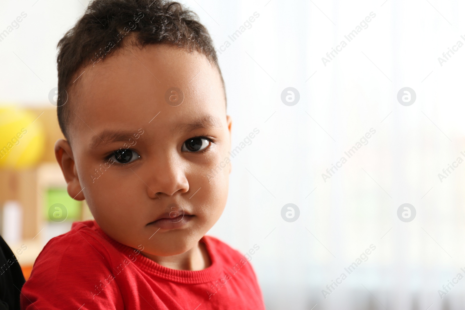 Photo of Cute little African-American child in kindergarten, space for text