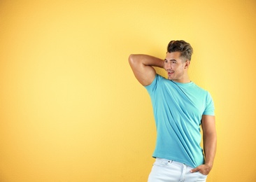 Young man in t-shirt on color background. Mockup for design