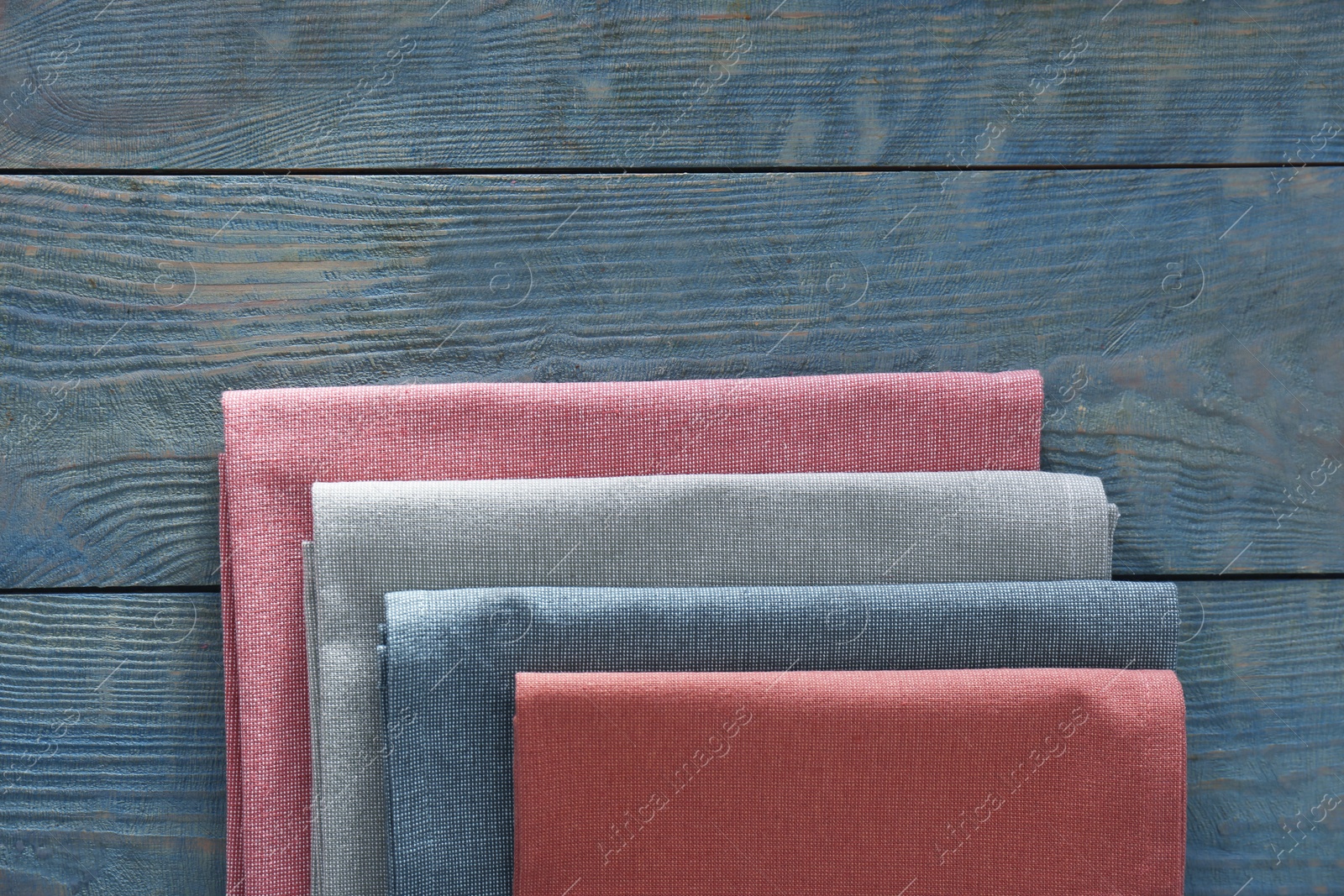 Photo of Different colorful napkins on wooden table, top view. Space for text