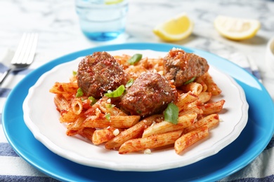 Delicious pasta with meatballs and tomato sauce on table, closeup
