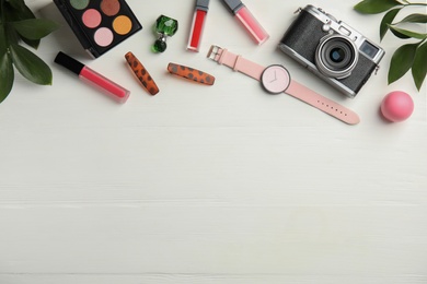 Photo of Flat lay composition with makeup products and camera on white wooden background. Space for text