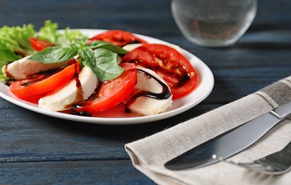 Photo of Plate with delicious fresh salad on table, closeup