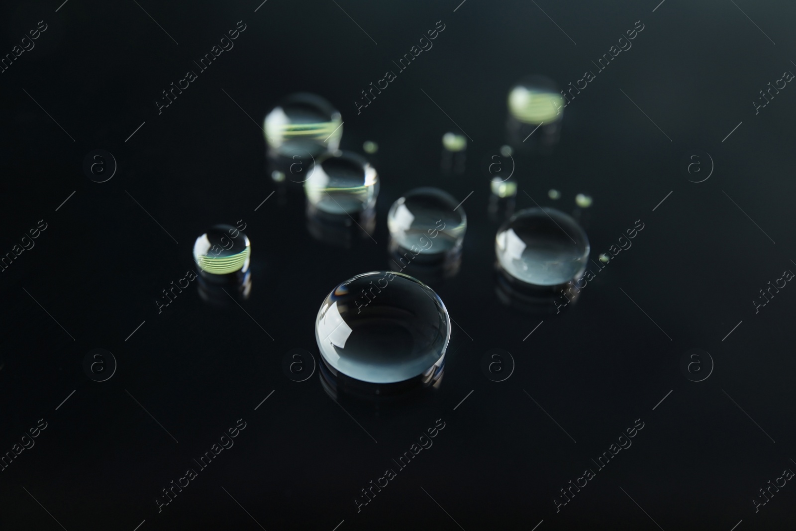 Photo of Many clean water drops on black background