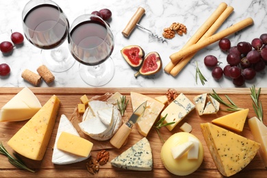 Photo of Flat lay composition with different types of delicious cheese on marble table