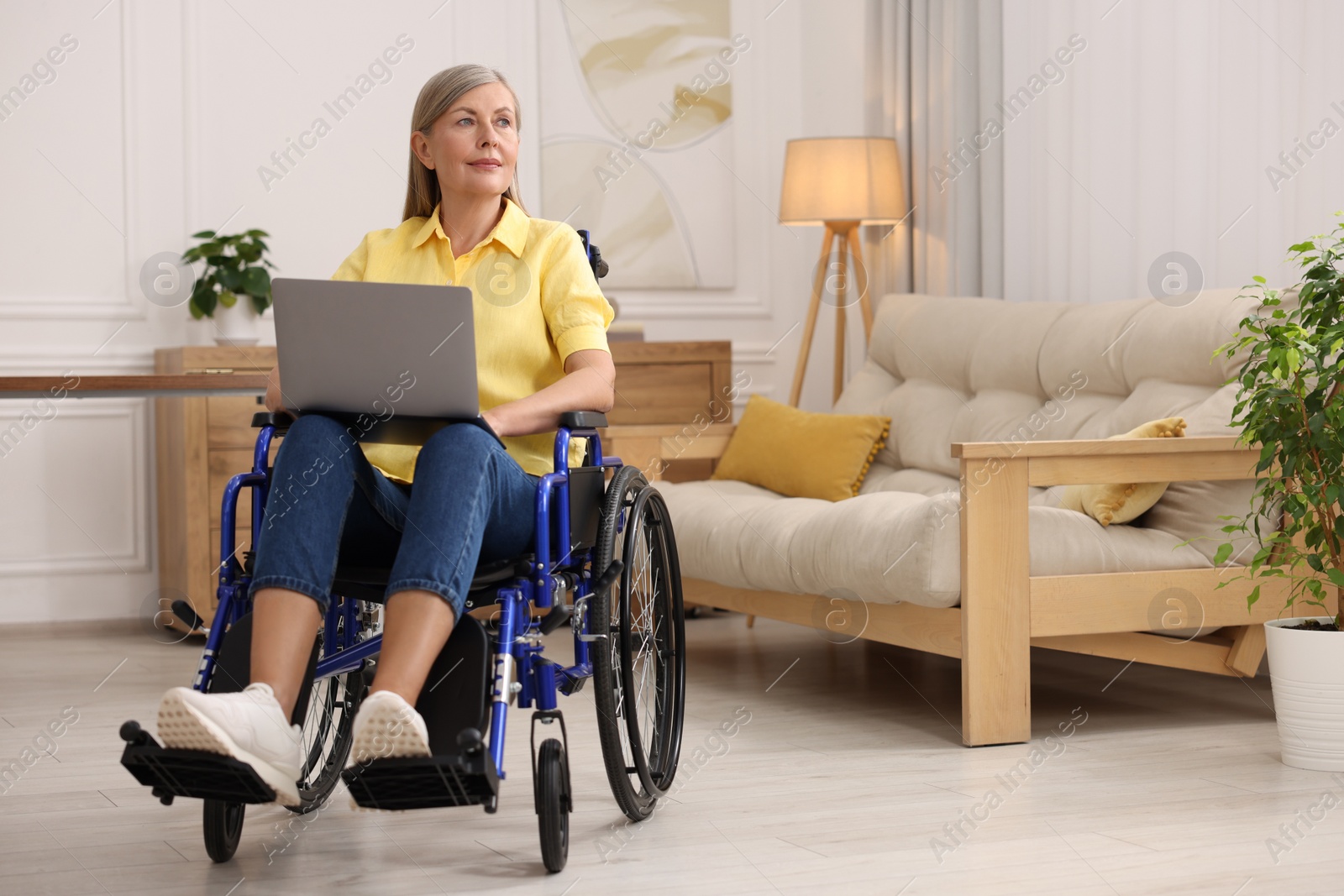 Photo of Woman in wheelchair using laptop at home