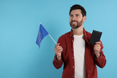 Photo of Immigration. Happy man with passport and flag of European Union on light blue background, space for text