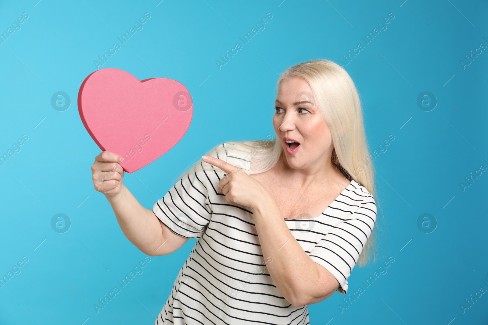 Photo of Portrait of mature woman with decorative heart on color background