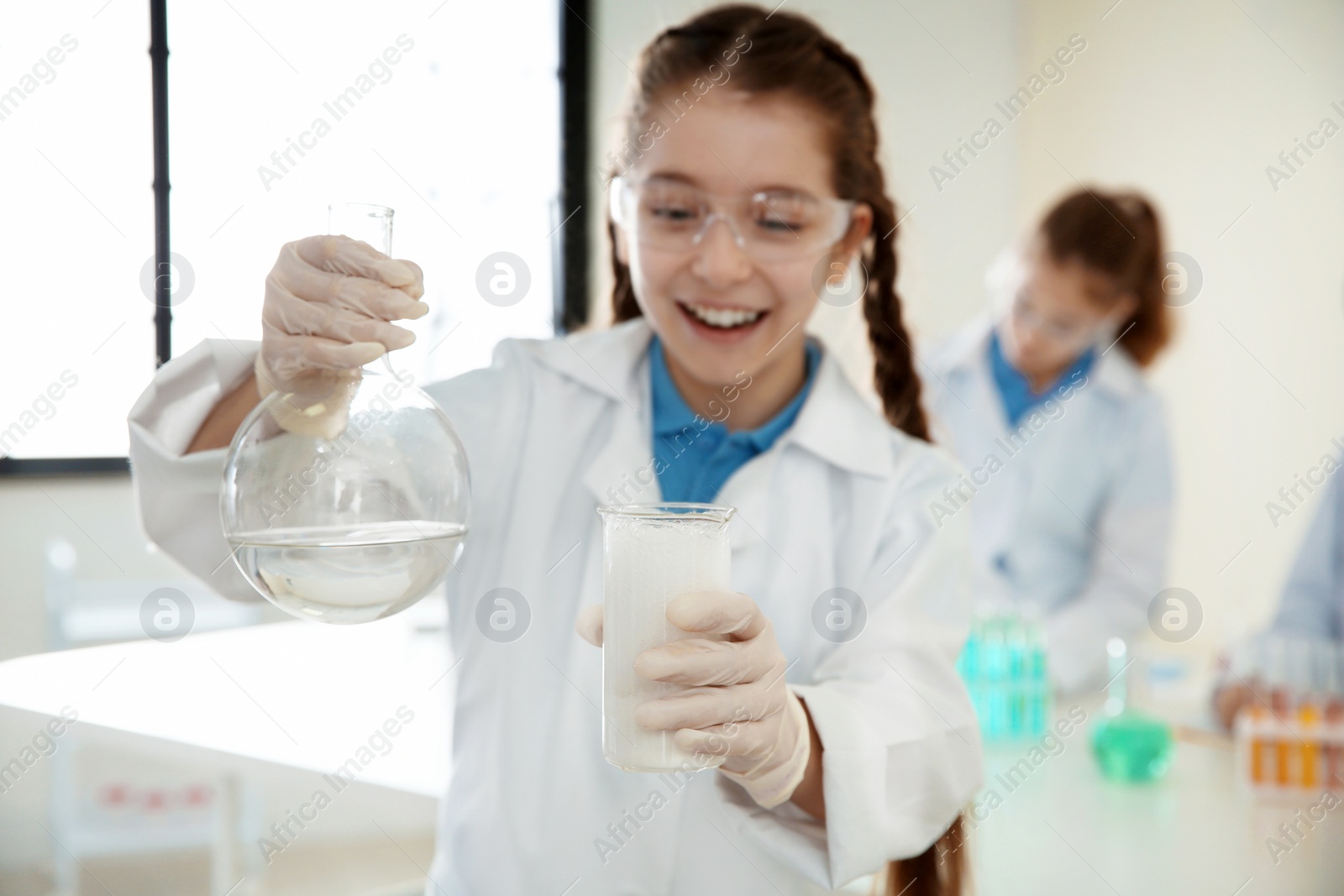 Photo of Schoolgirl making experiment in chemistry class, closeup