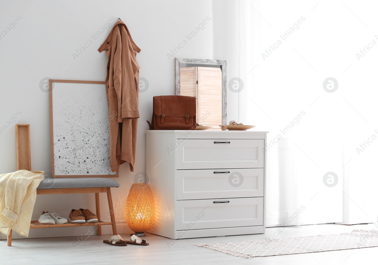 Photo of Modern hallway interior with shoe storage bench and chest of drawers. Space for text