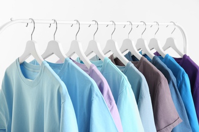 Photo of Men's clothes hanging on wardrobe rack against white background