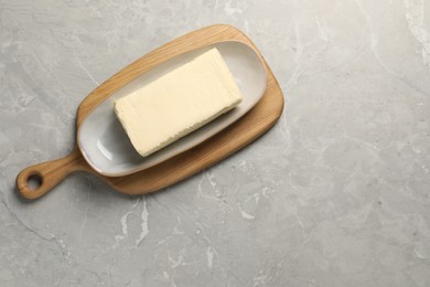 Photo of Block of tasty butter on grey table, top view. Space for text