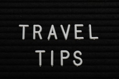 Photo of Phrase Travel Tips on black letter board as background, top view
