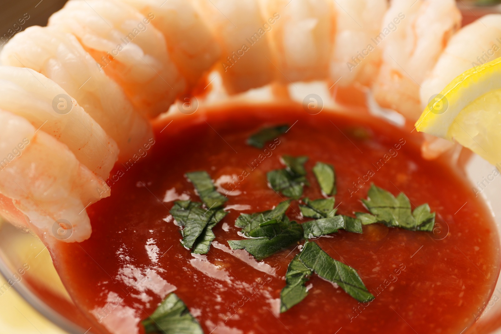 Photo of Tasty shrimp cocktail with sauce in glass, closeup