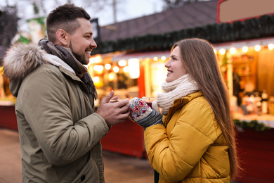 Photo of Happy couple with mulled wine at winter fair