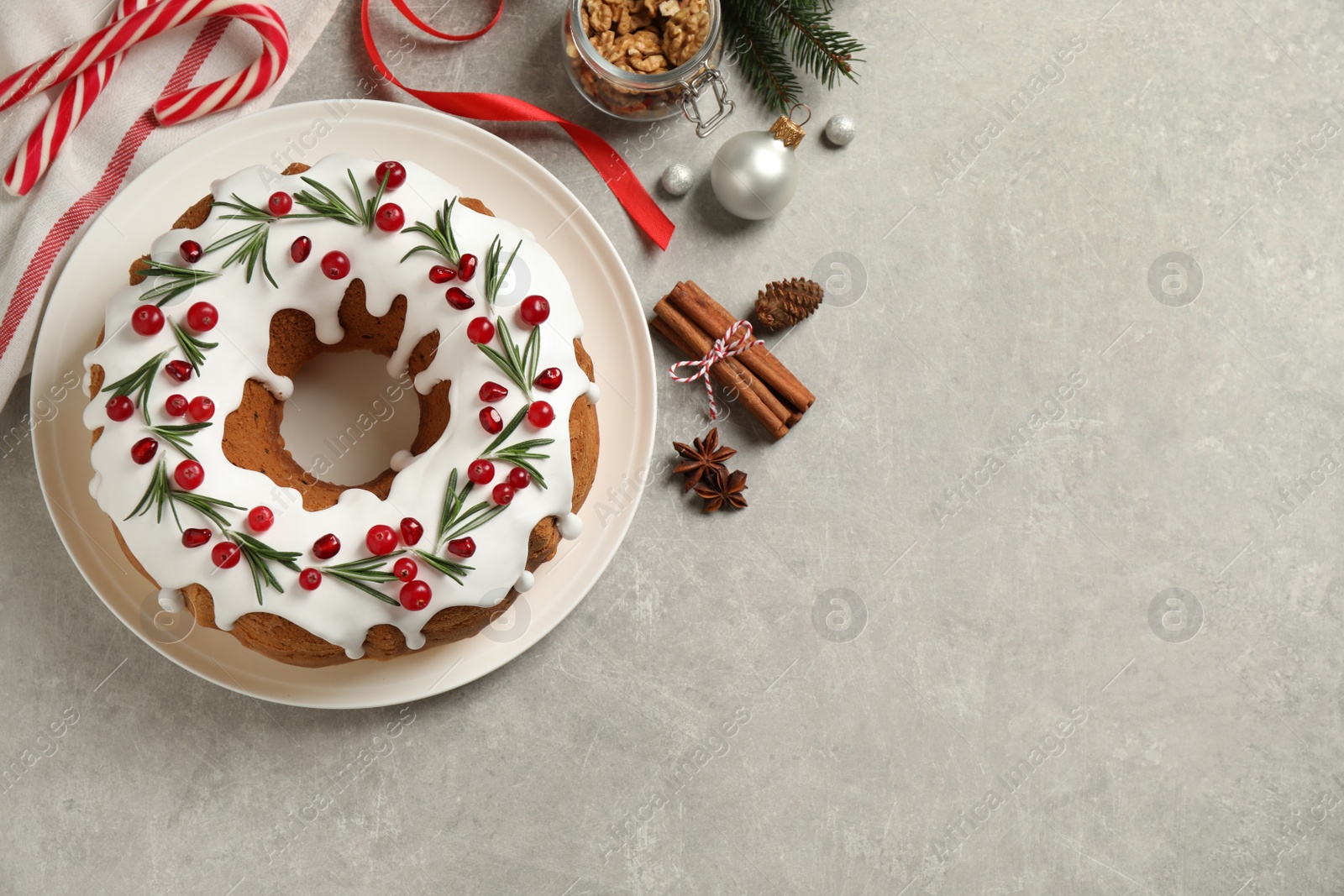 Photo of Flat lay composition with traditional Christmas cake and decorations on light grey table, space for text