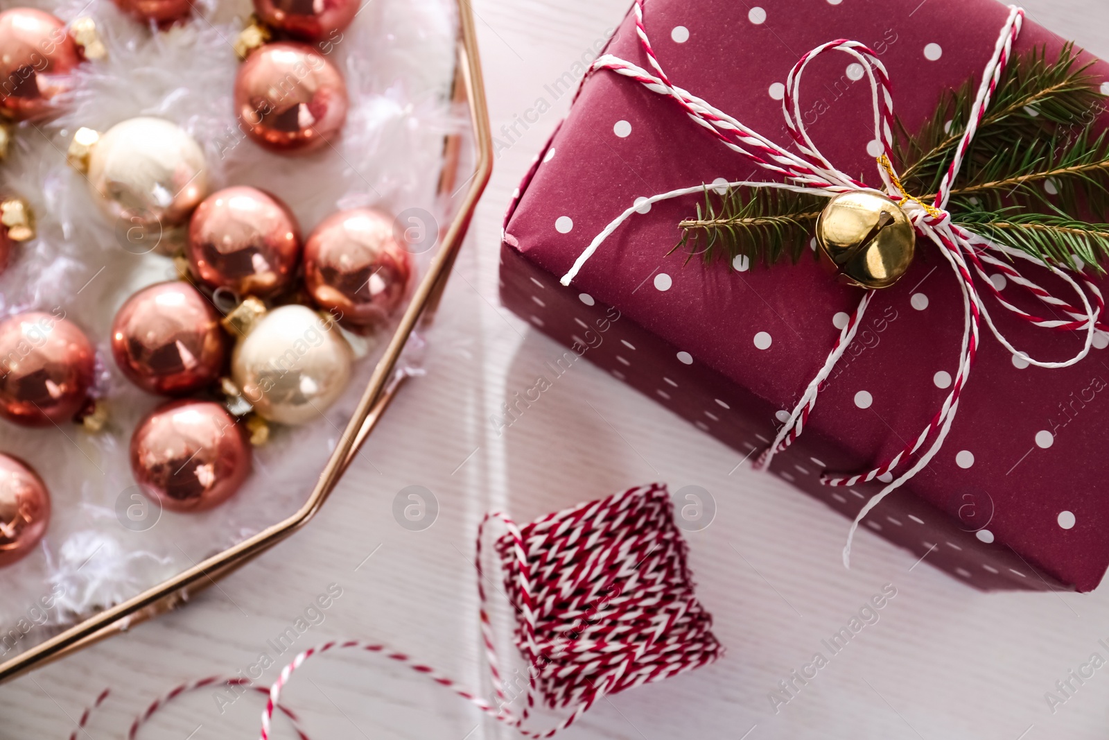 Photo of Beautiful Christmas baubles and gift box on white wooden table, flat lay