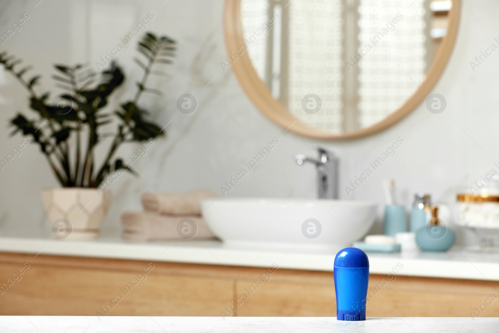 Photo of Stick deodorant on table in bathroom, space for text