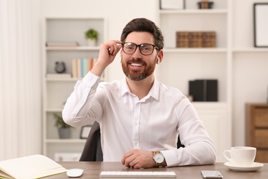 Happy businessman having online video call at wooden desk indoors, view from web camera