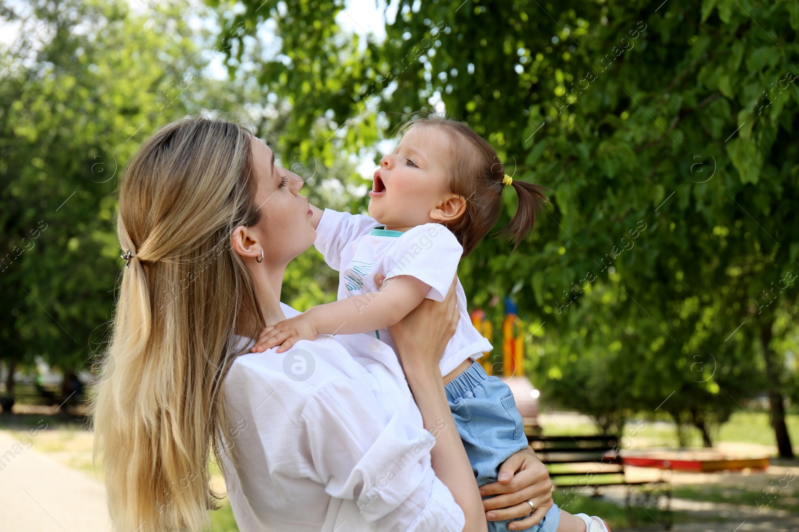 Photo of Mother with her daughter spending time together in park. Space for text