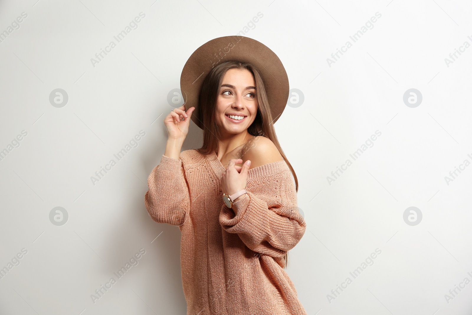 Photo of Beautiful young woman in warm sweater with hat on white background