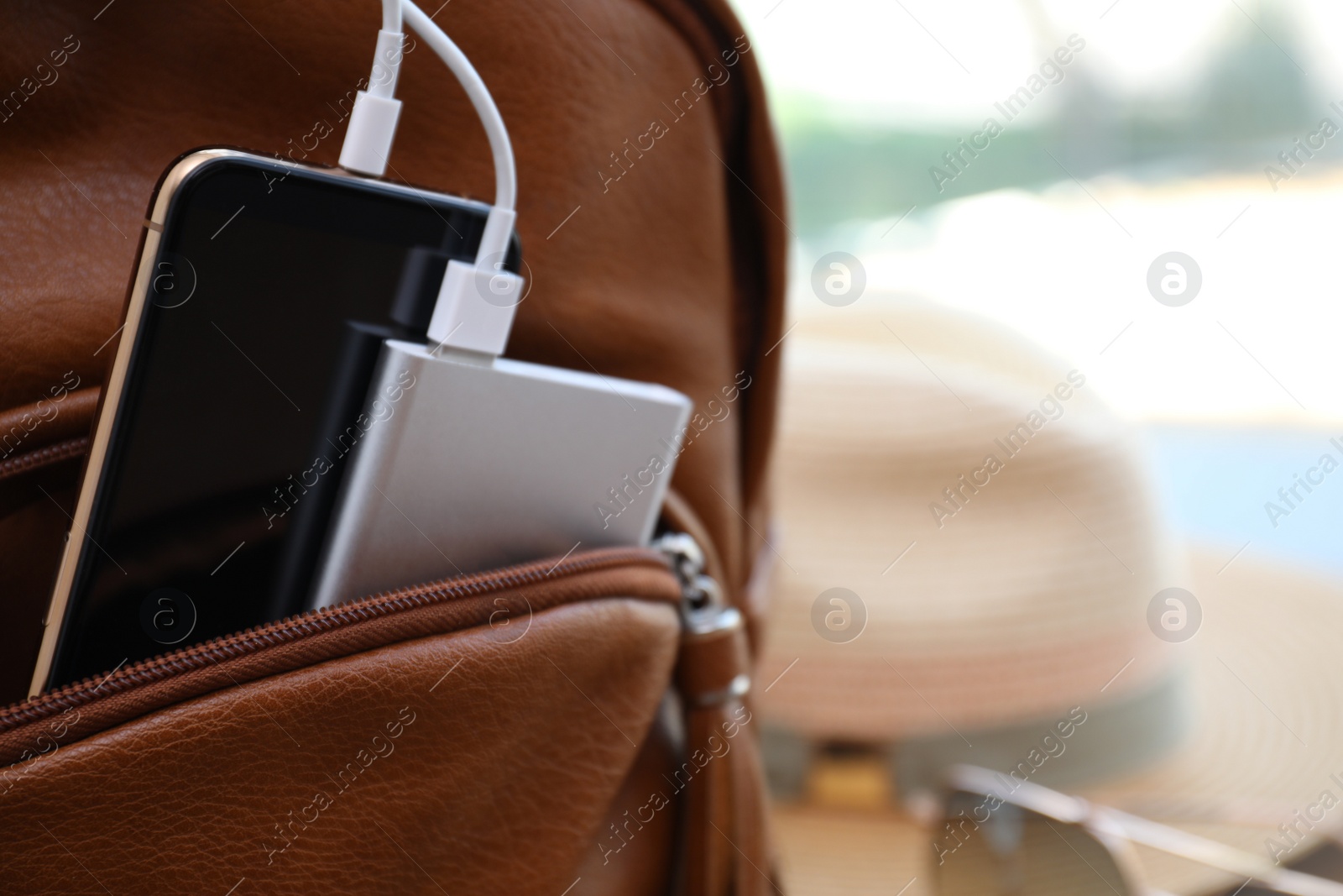 Photo of Charging mobile phone with power bank in backpack, closeup. Space for text