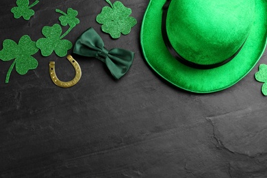 Photo of Leprechaun's hat and St. Patrick's day decor on black background, flat lay. Space for text