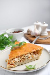 Slice of delicious meat pie with basil on table, space for text