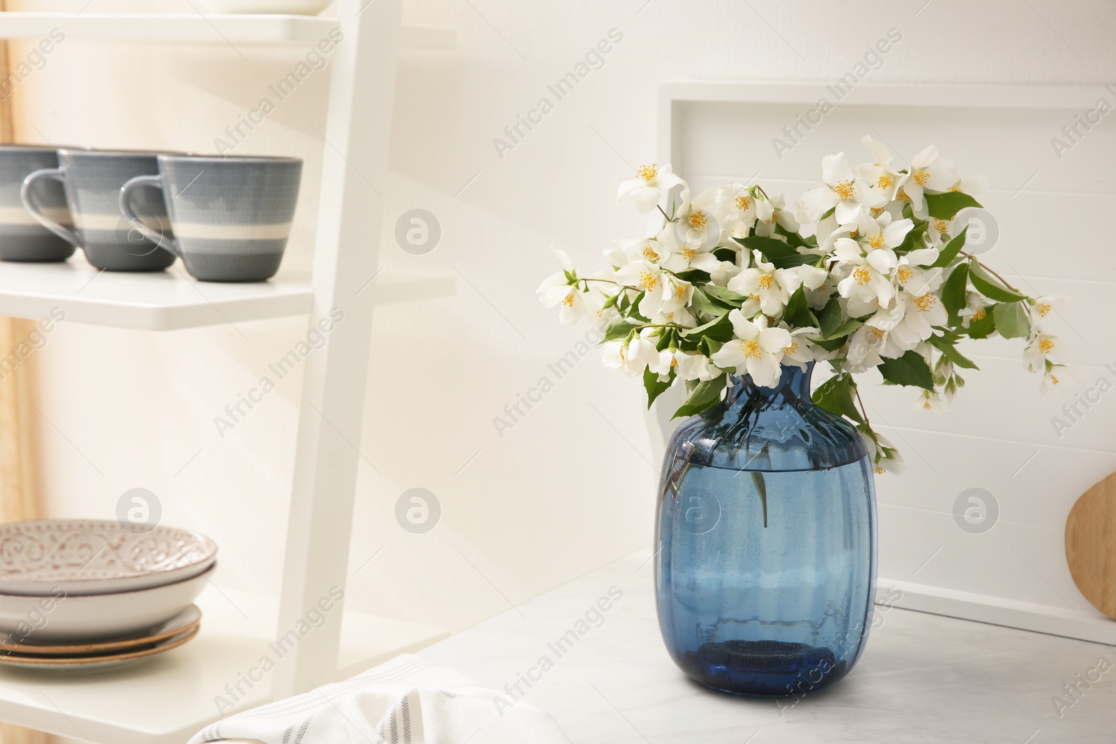 Photo of Bouquet of beautiful jasmine flowers on countertop in kitchen