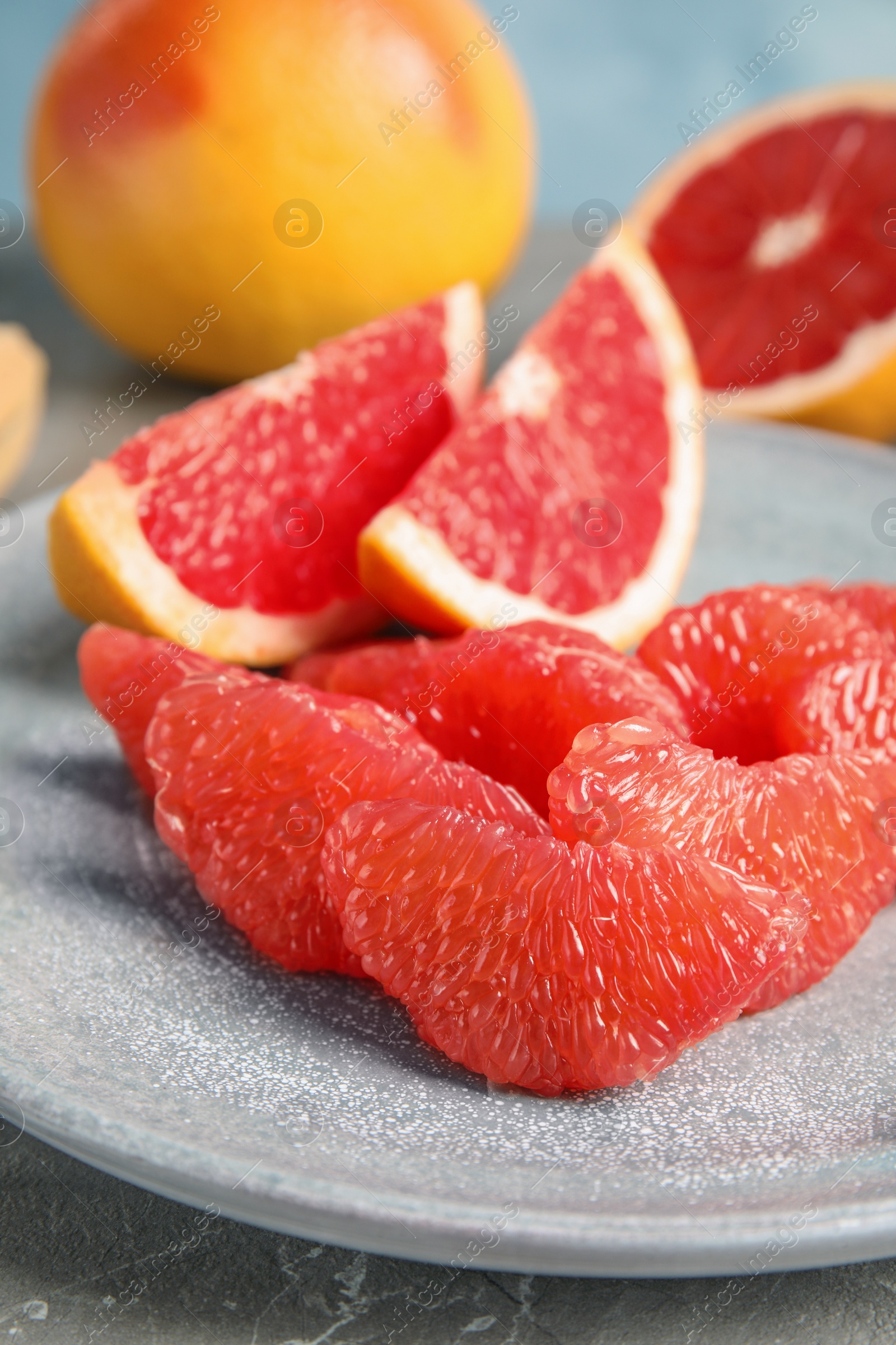 Photo of Plate with ripe grapefruit on table. Fresh fruit