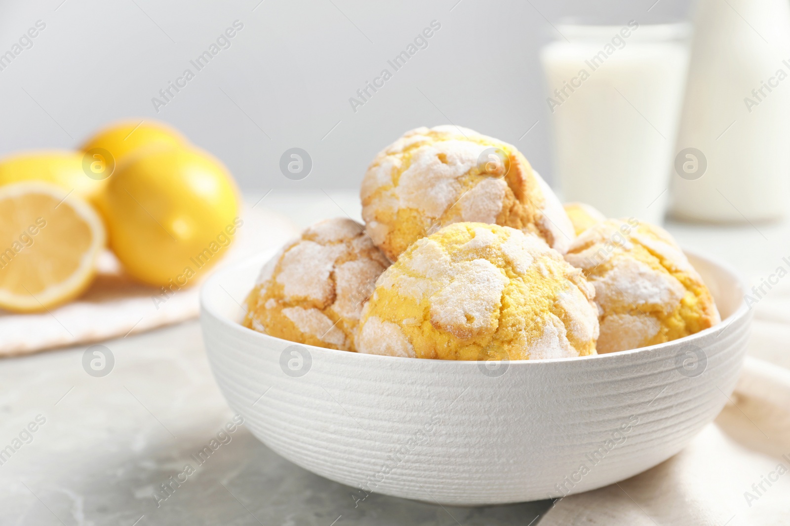 Photo of Delicious lemon cookies in bowl on grey table, closeup