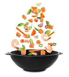 Image of Different tasty ingredients falling into wok on white background