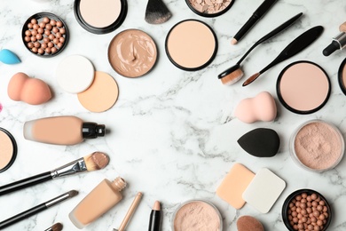 Photo of Flat lay composition with skin foundation, powder and beauty accessories on marble background. Space for text