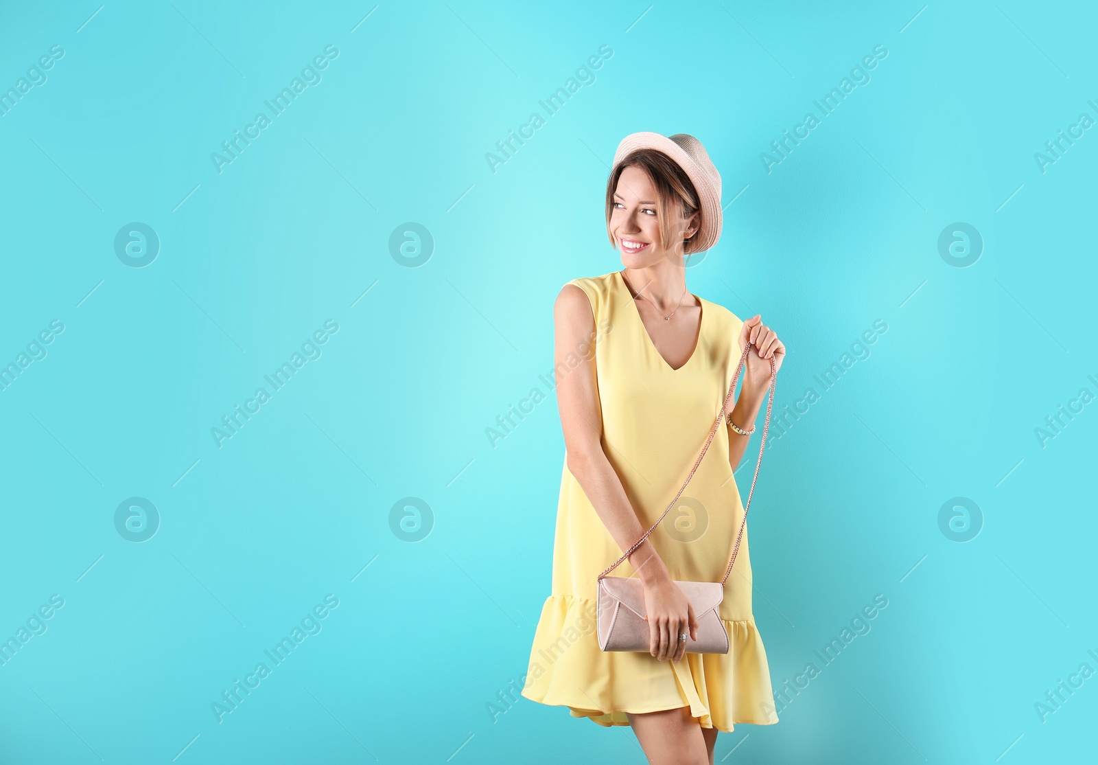 Photo of Portrait of young woman in stylish outfit with purse on color background