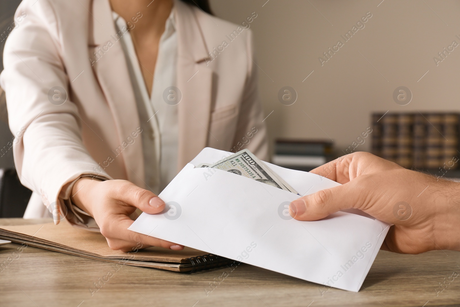 Photo of Man giving bribe to woman at table, closeup