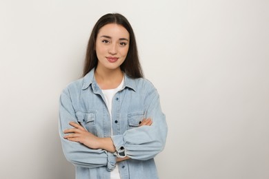 Photo of Portrait of beautiful young woman in jeans jacket on white background. Space for text