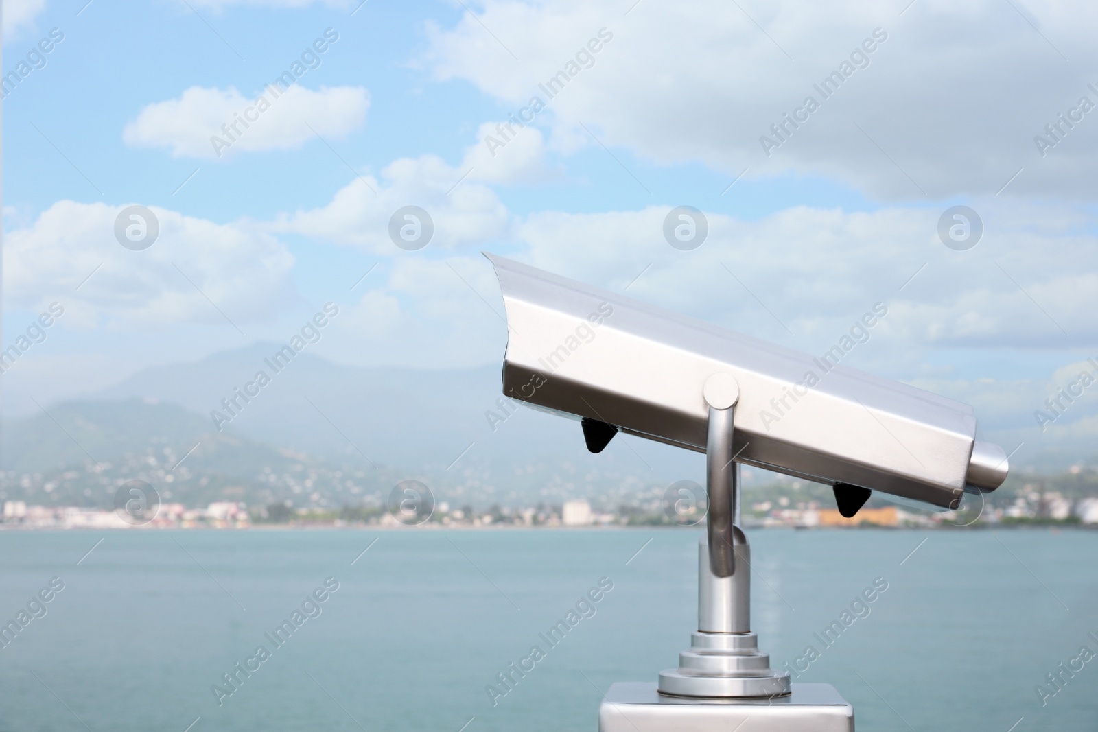 Photo of Metal tower viewer installed near sea, space for text. Mounted binoculars