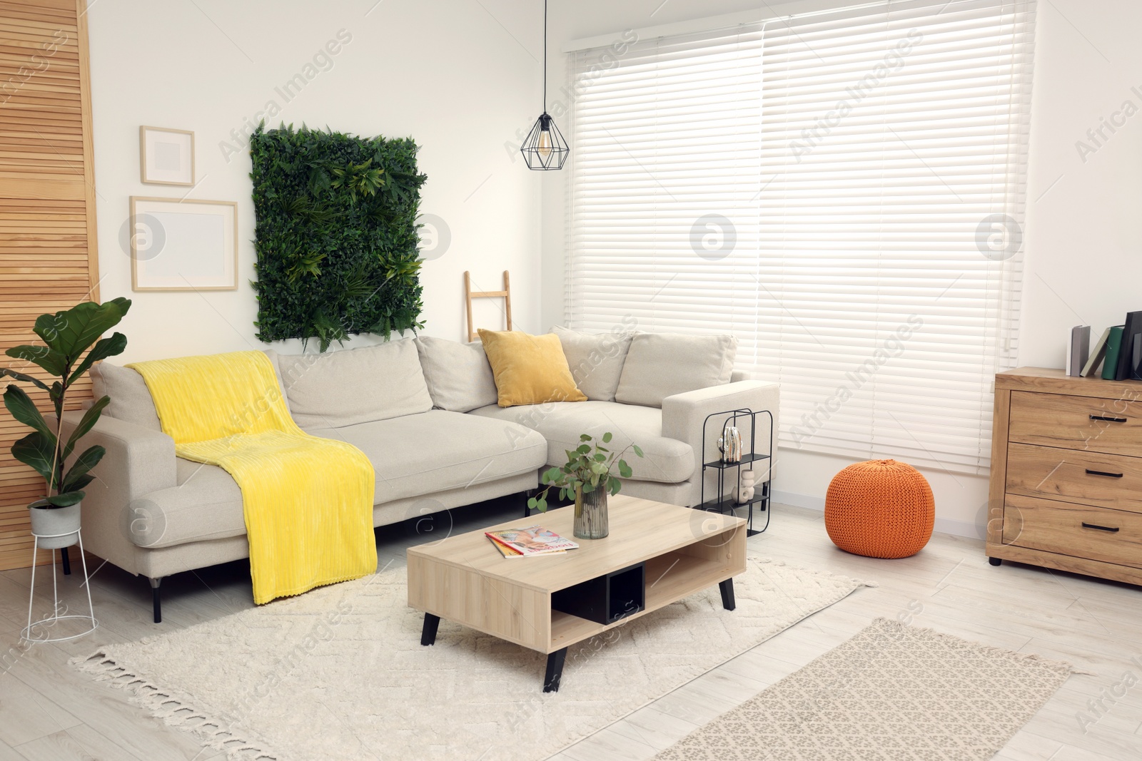 Photo of Green artificial plant wall panel and comfortable furniture in cozy living room. Interior design