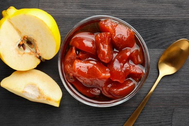 Photo of Quince jam in glass bowl, spoon and fresh raw fruits on grey wooden table, flat lay