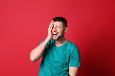 Handsome man laughing on red background. Funny joke