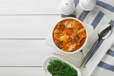 Photo of Tasty cabbage soup with meat and carrot served on white wooden table, flat lay. Space for text