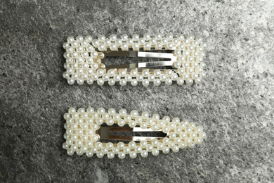 Beautiful hair clips on grey table, flat lay