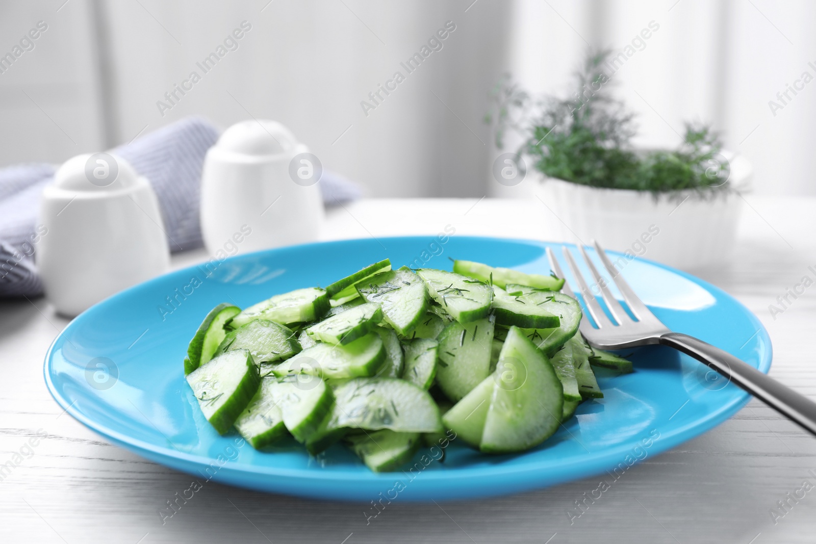 Photo of Plate of tasty cucumber salad on table