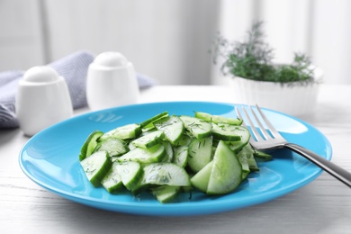 Plate of tasty cucumber salad on table