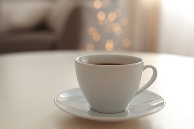 Photo of Cup of aromatic coffee on table indoors. Bokeh effect