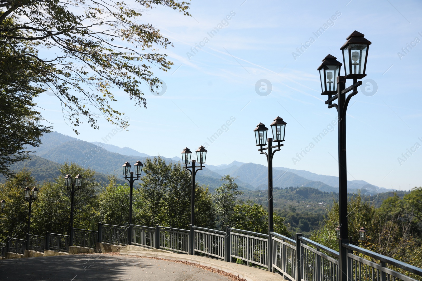 Photo of Beautiful street light lamps near pathway outdoors on sunny day