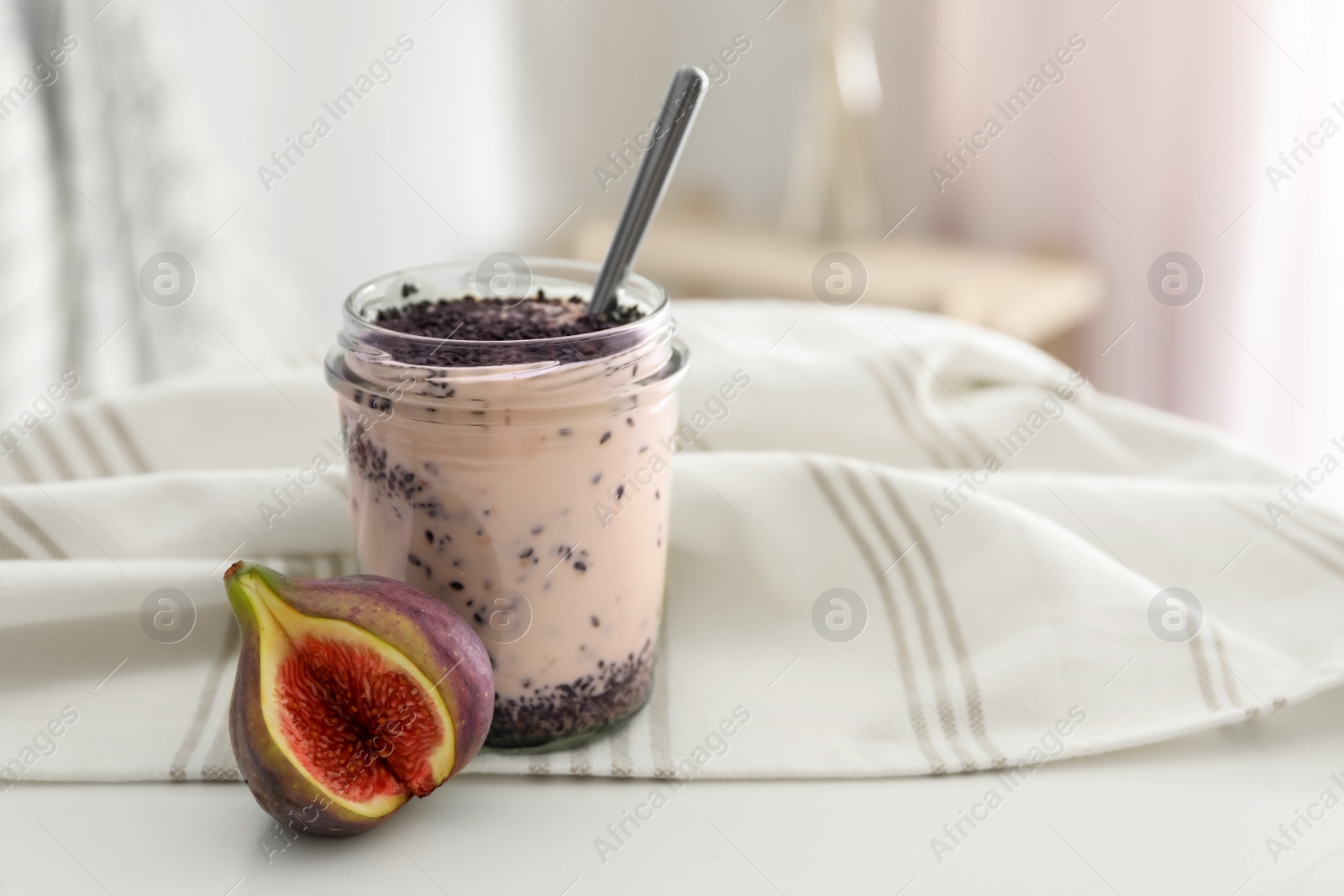 Photo of Delicious fig smoothie in glass jar on white table indoors